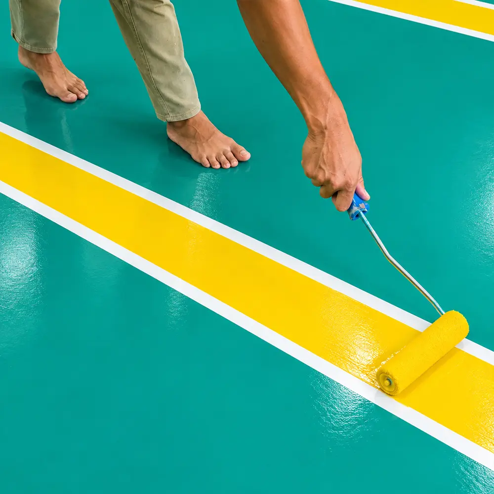 Worker applying yellow line marking