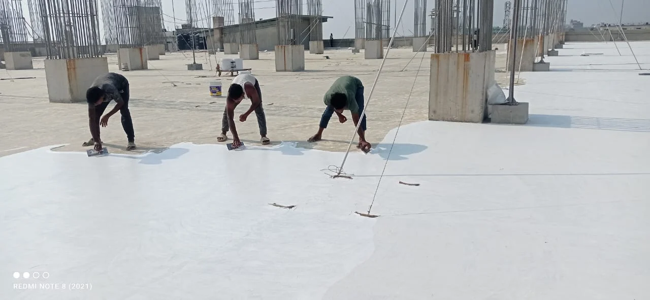 Fountech team rolling acrylic waterproofing coating onto a concrete roof