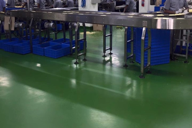Green PU floor under stainless steel tables in a food processing area